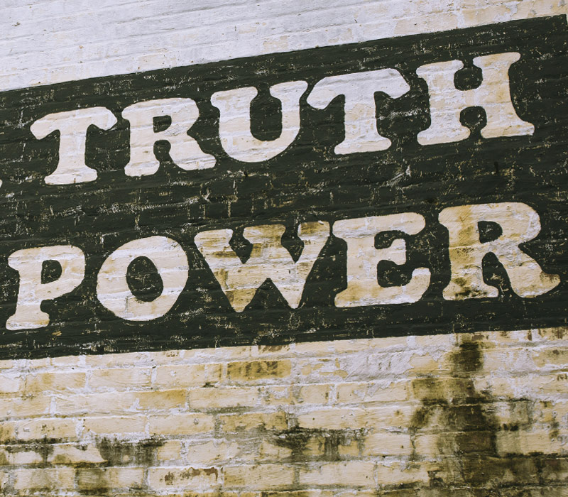 dirsy brick wall that says Truth Power