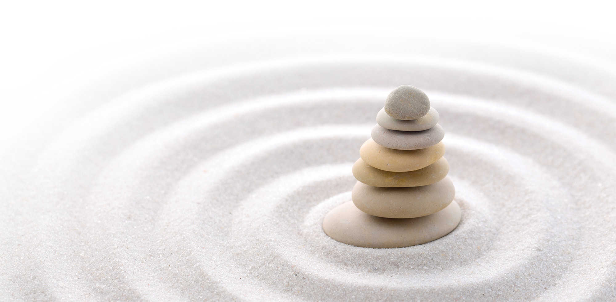 zen stacking stones in sand circles