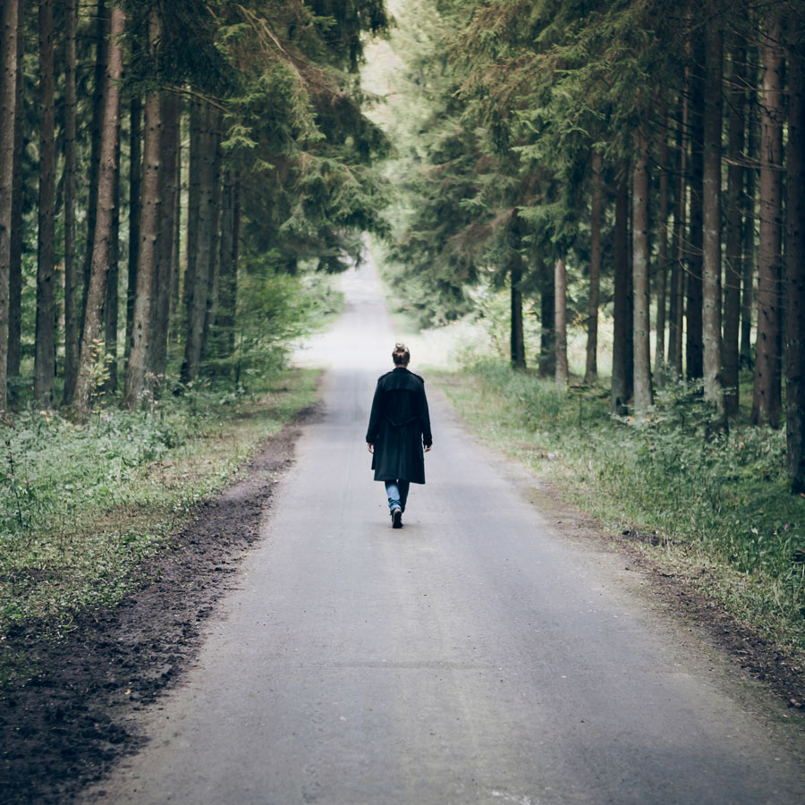 woman waking on a road in the woods