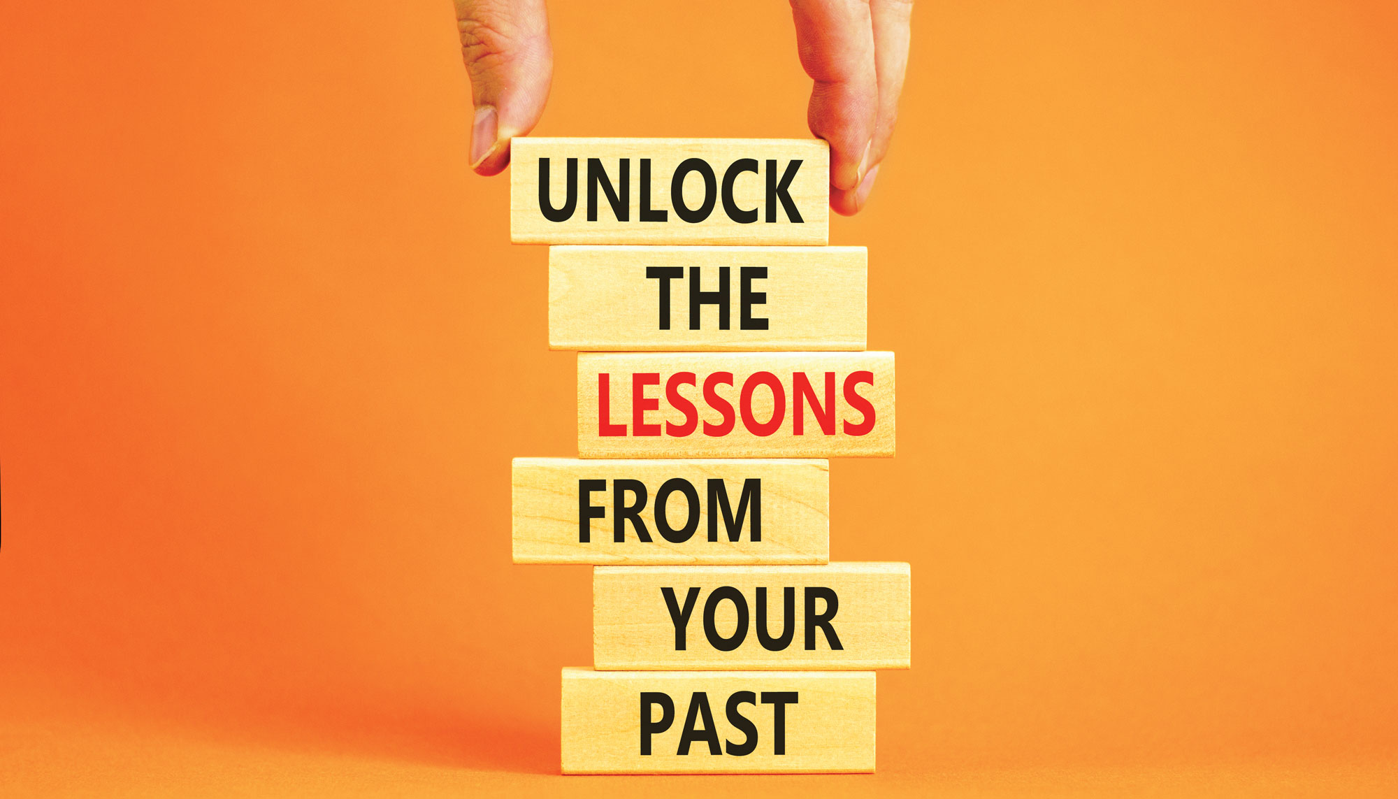 stacked blocks with words that read "Unlock the lessons from your past"