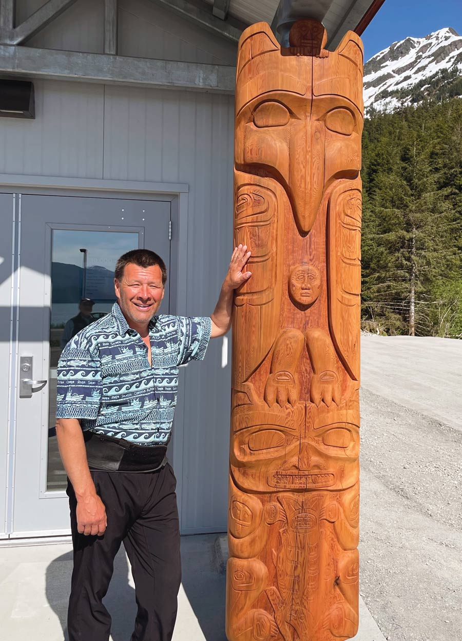 Carver Mike Webber with his totem hewn from a 850-year-old tree at the Prince William Science Center