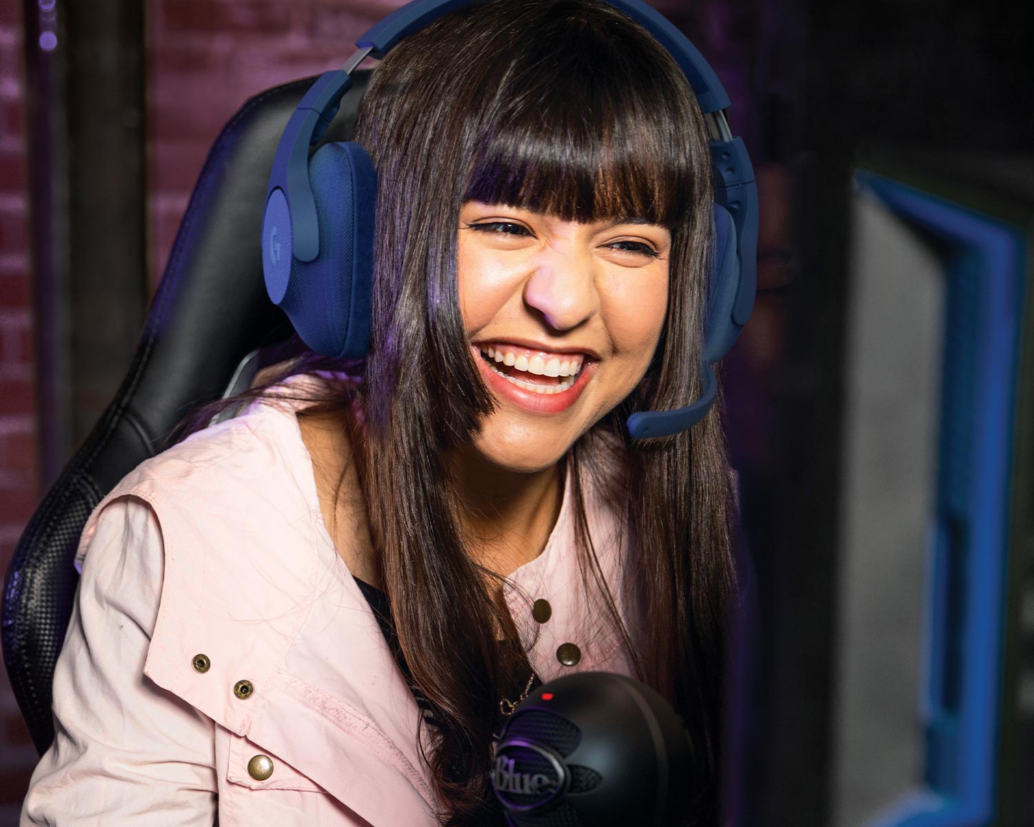 a woman smiles while wearing a microphone headset
