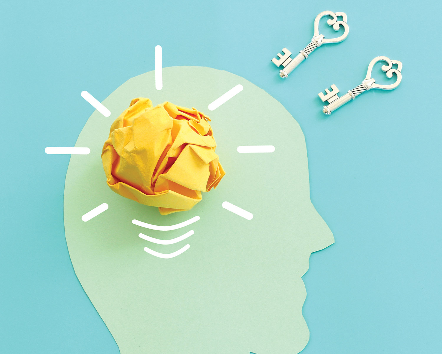 a paper art graphic of a light green human profile with a bright yellow ball of paper for as an active brain and keys floating just outside the profile